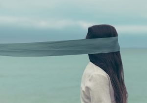 blindfolded woman on a beach