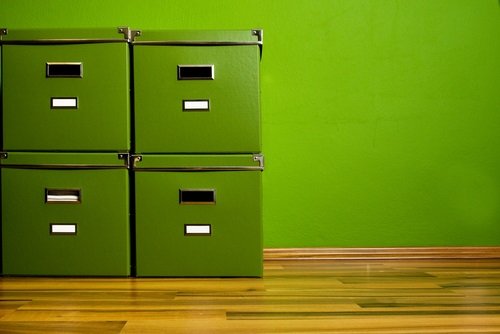 Green bankers boxes on a parquet floor